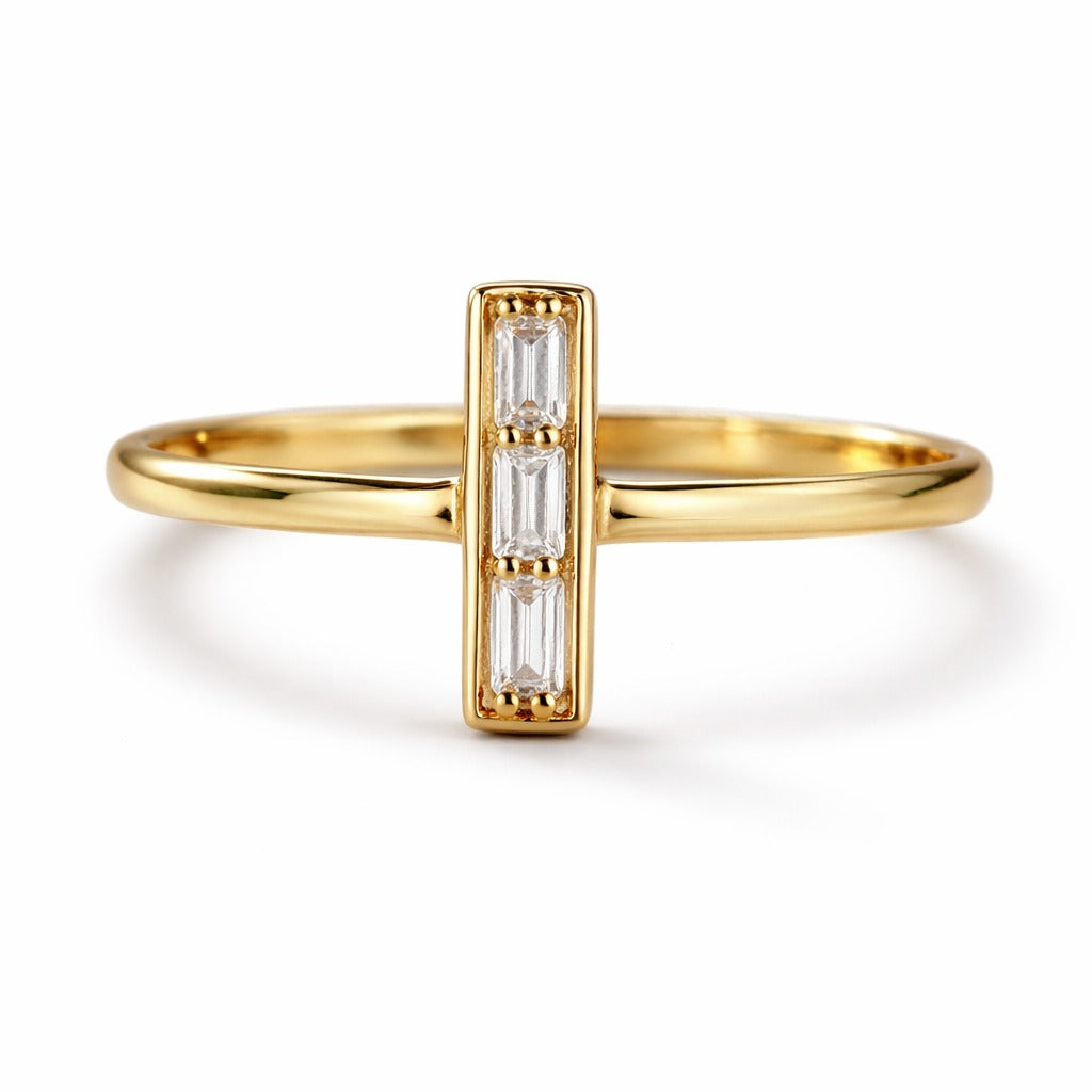 Gold ring with baguette cut diamonds on a white background