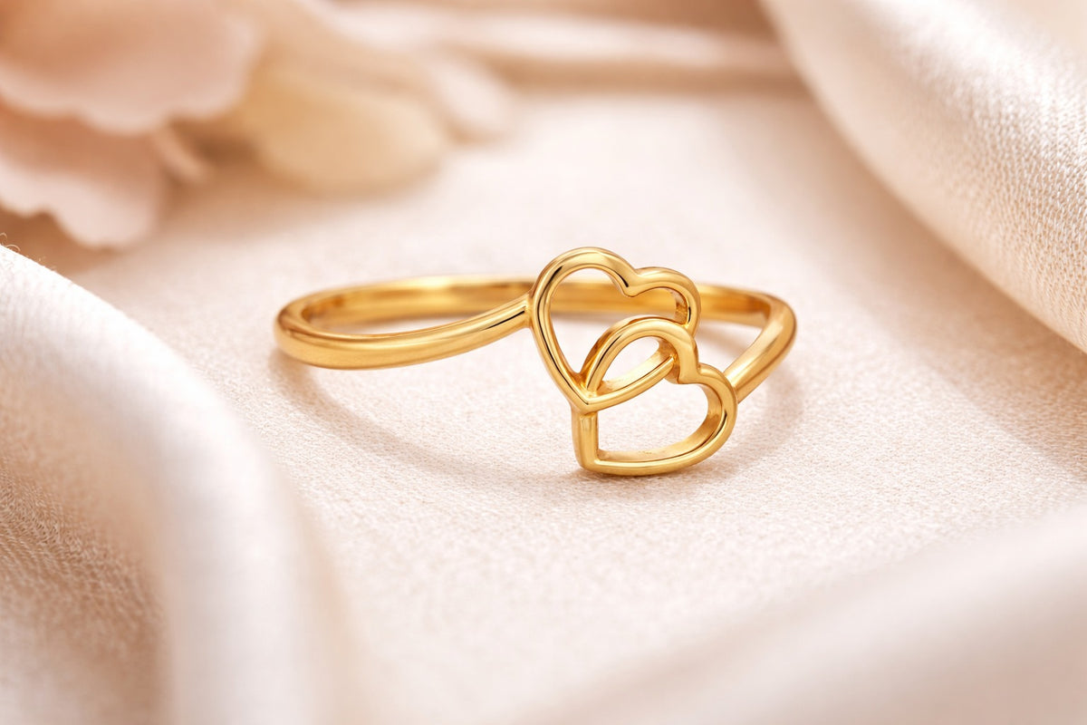 Gold heart-shaped ring on a soft beige fabric background