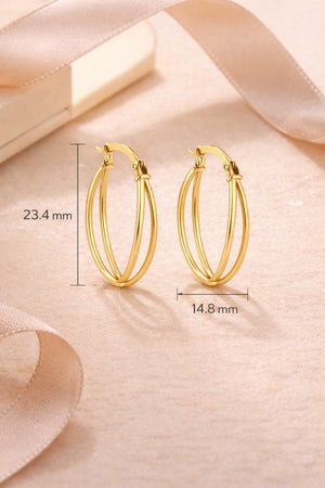 Gold hoop earrings on a soft pink fabric background with measurements indicated.