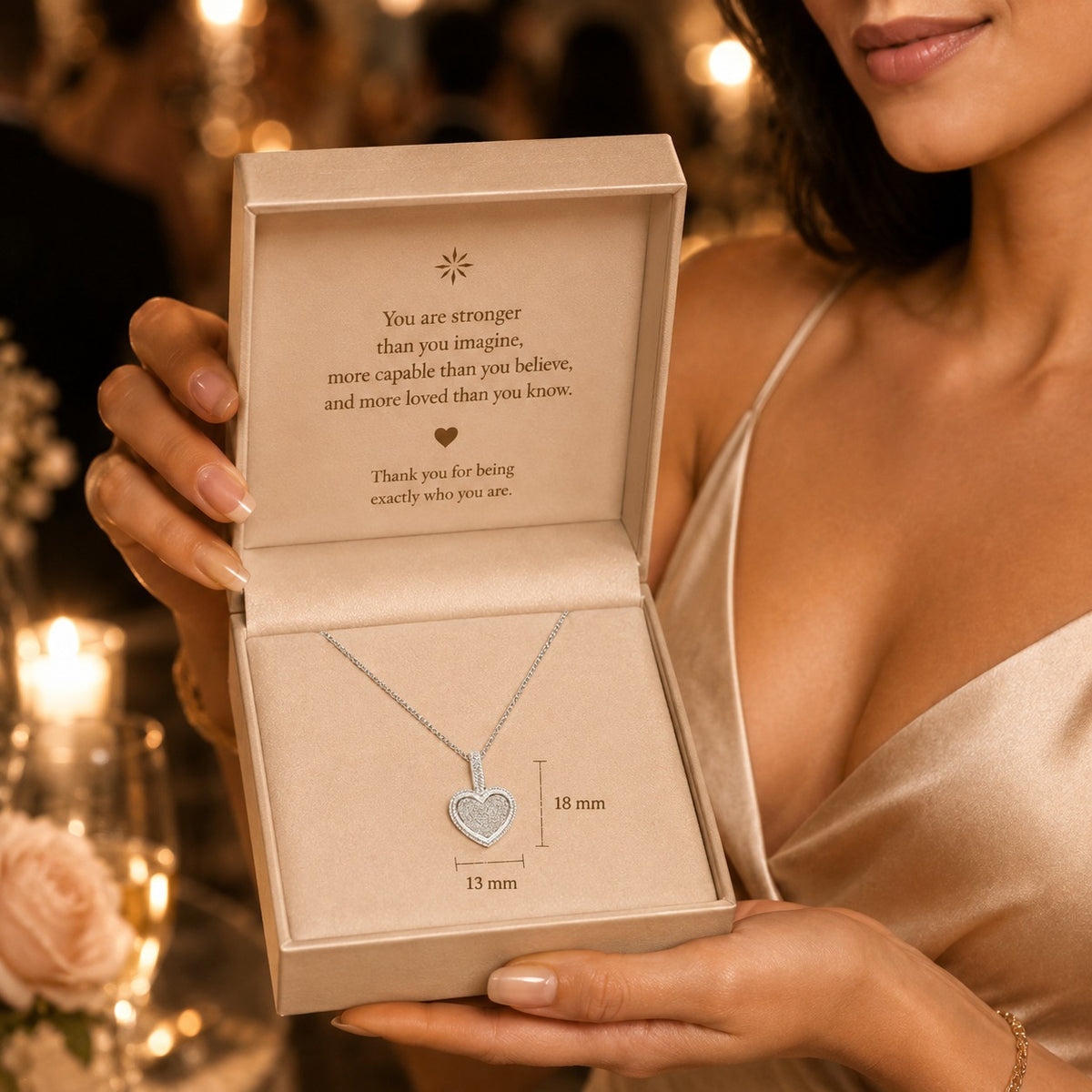 Necklace with heart pendant in an open jewelry box held by a person.