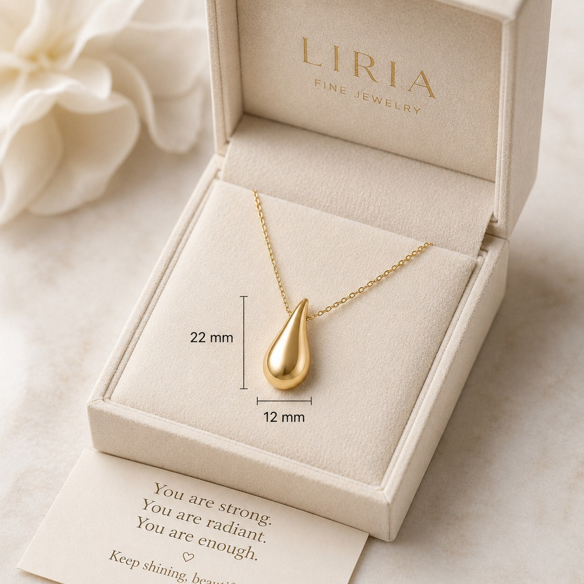 Gold teardrop necklace in a LIRIA jewelry box with a message card.