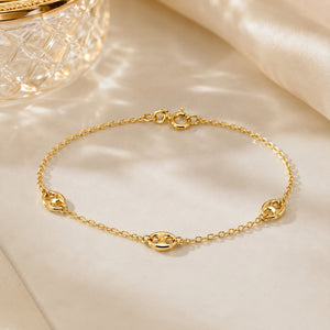 Gold bracelet on a beige fabric background