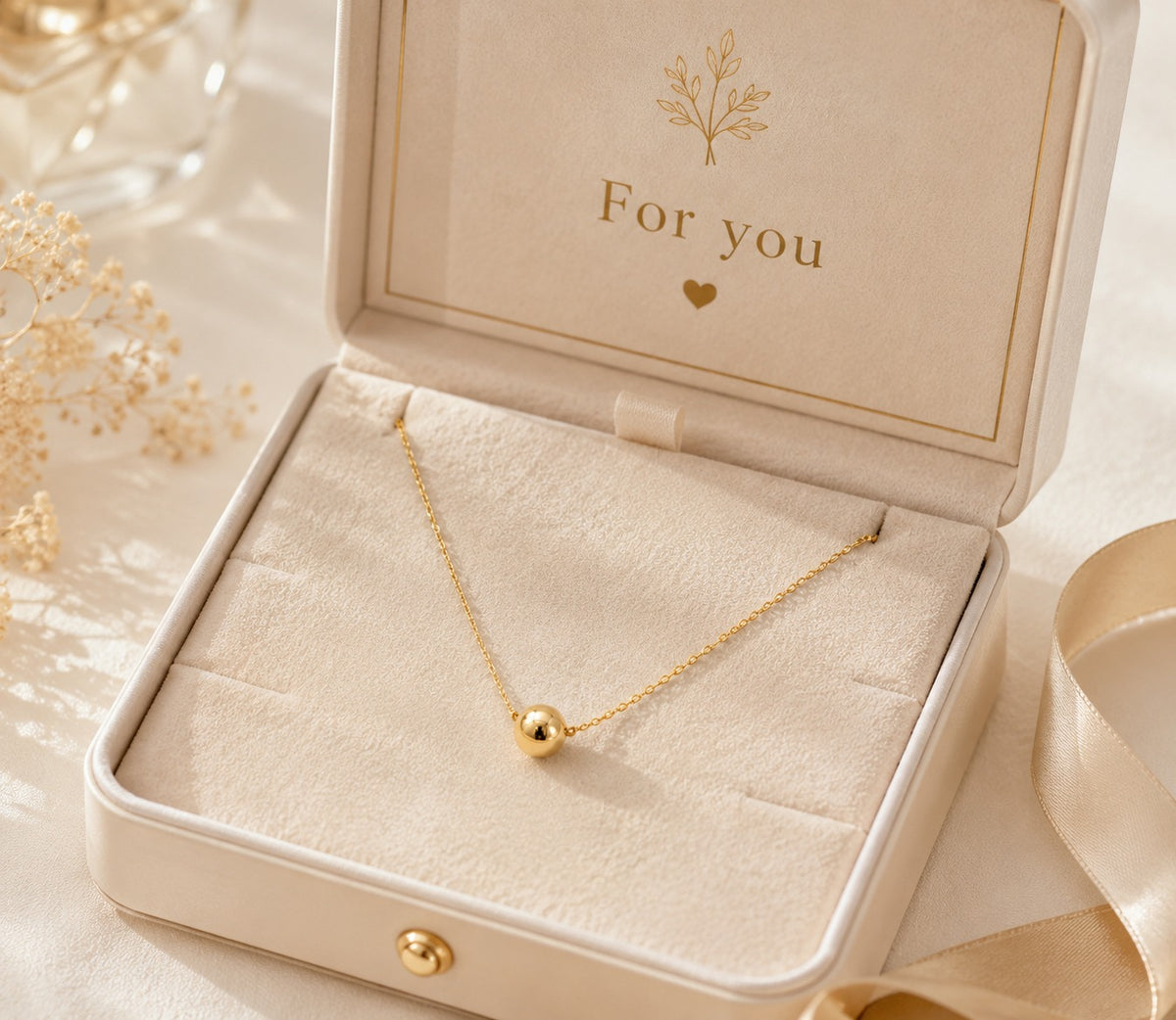 Gold necklace in an open jewelry box with 'For you' inscription.