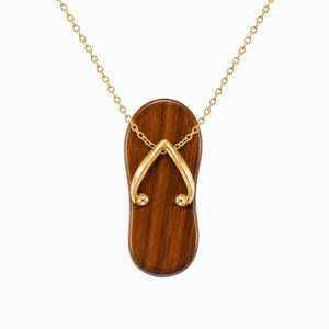 Wooden flip-flop pendant with gold chain on a white background