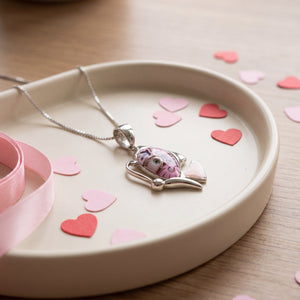 Necklace with a pink pendant on a white dish with heart-shaped confetti