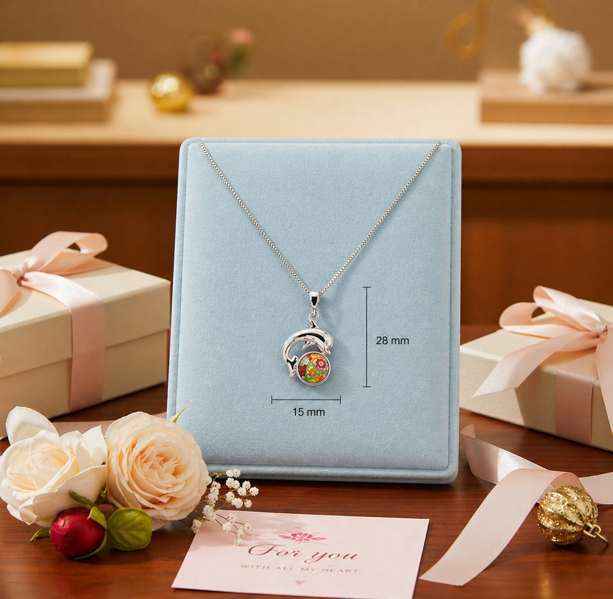 Necklace with pendant on a blue display card, surrounded by gift boxes and flowers on a wooden surface.