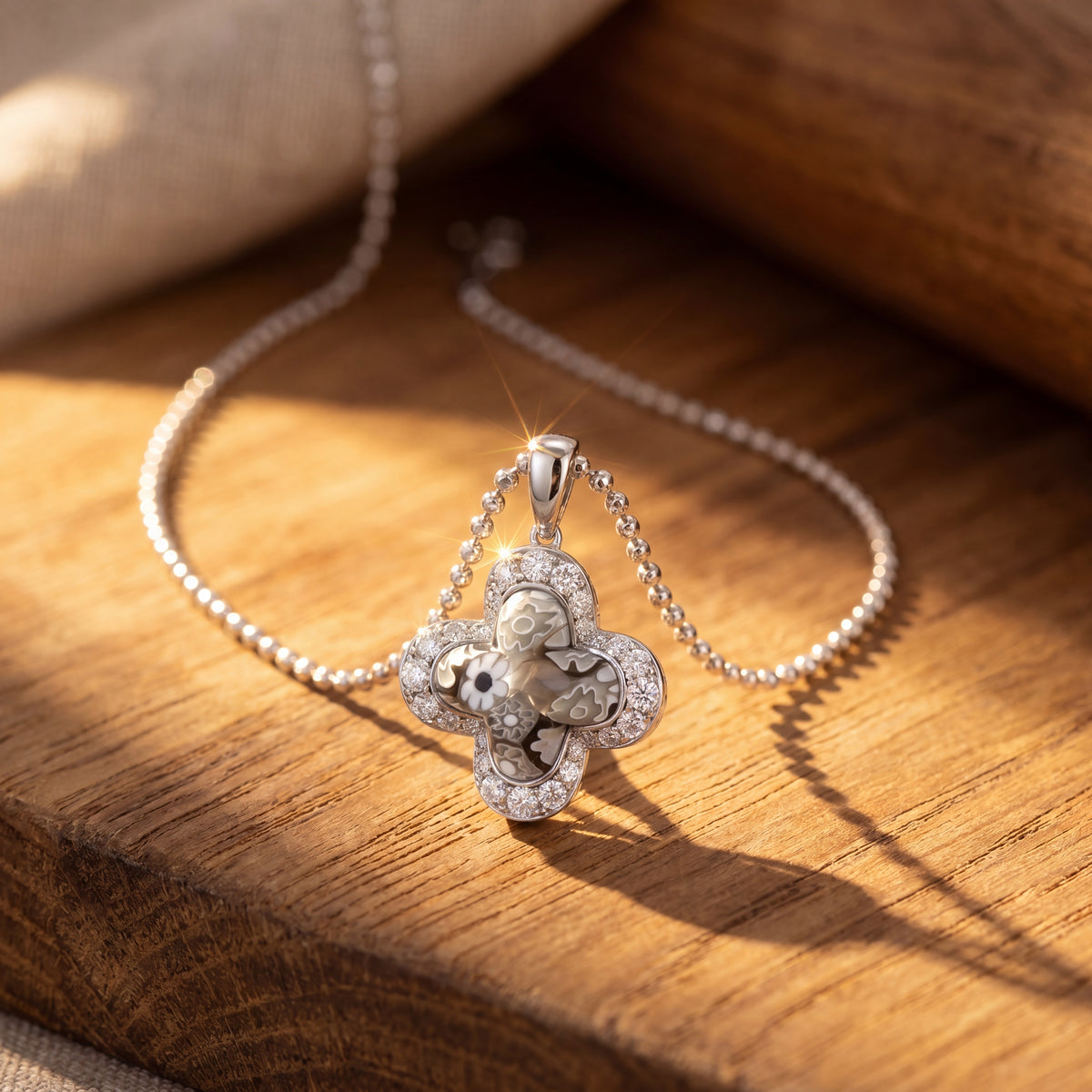Silver floral pendant necklace on a wooden surface