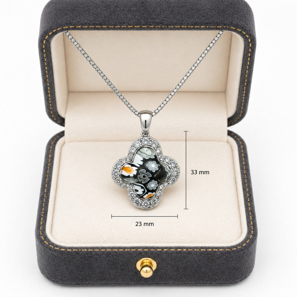 Necklace with a clover-shaped pendant in a jewelry box, showing measurements.