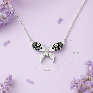 Butterfly-shaped necklace with floral details on a purple background