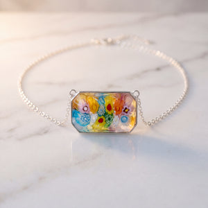 Necklace with a colorful floral pendant on a marble surface