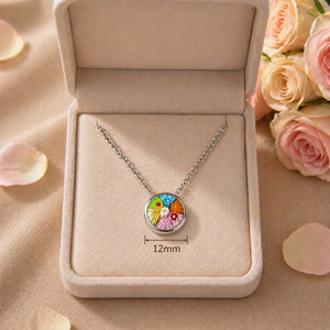 Necklace with a colorful pendant in an open jewelry box, surrounded by roses and petals.