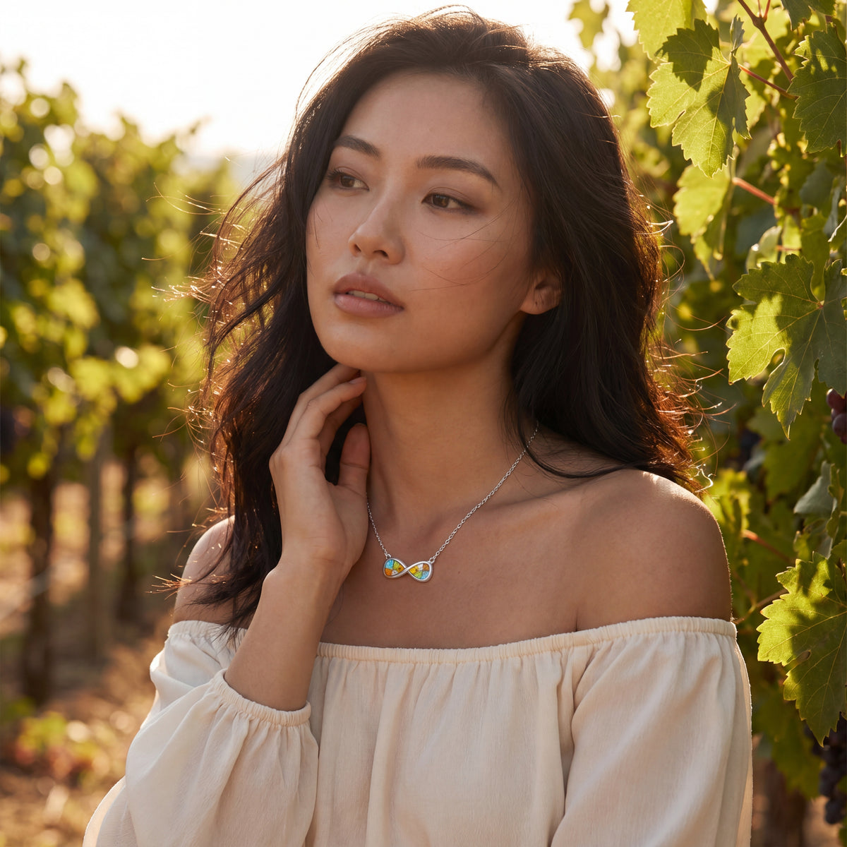 Woman in a vineyard wearing a necklace with a butterfly pendant
