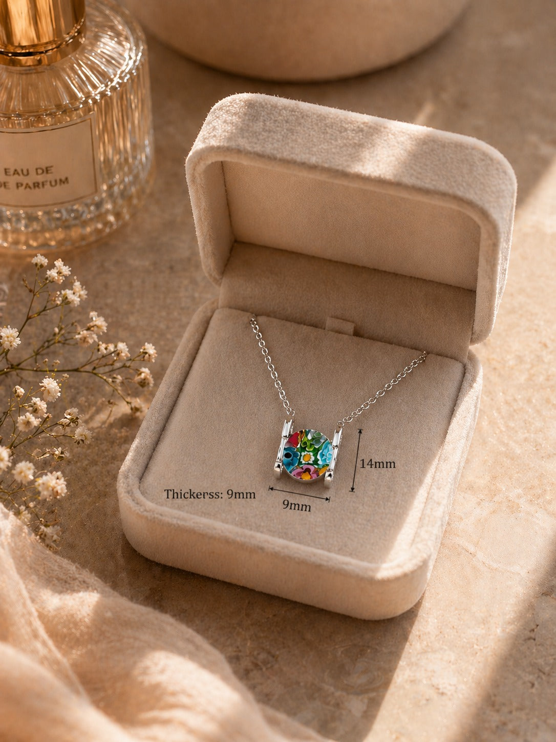 Necklace with a colorful pendant in an open jewelry box on a soft surface.