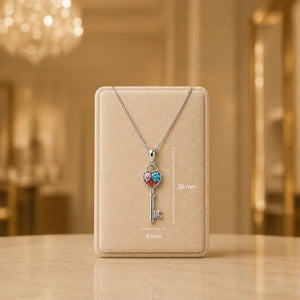 Necklace with a key-shaped pendant on a beige display card against a blurred background