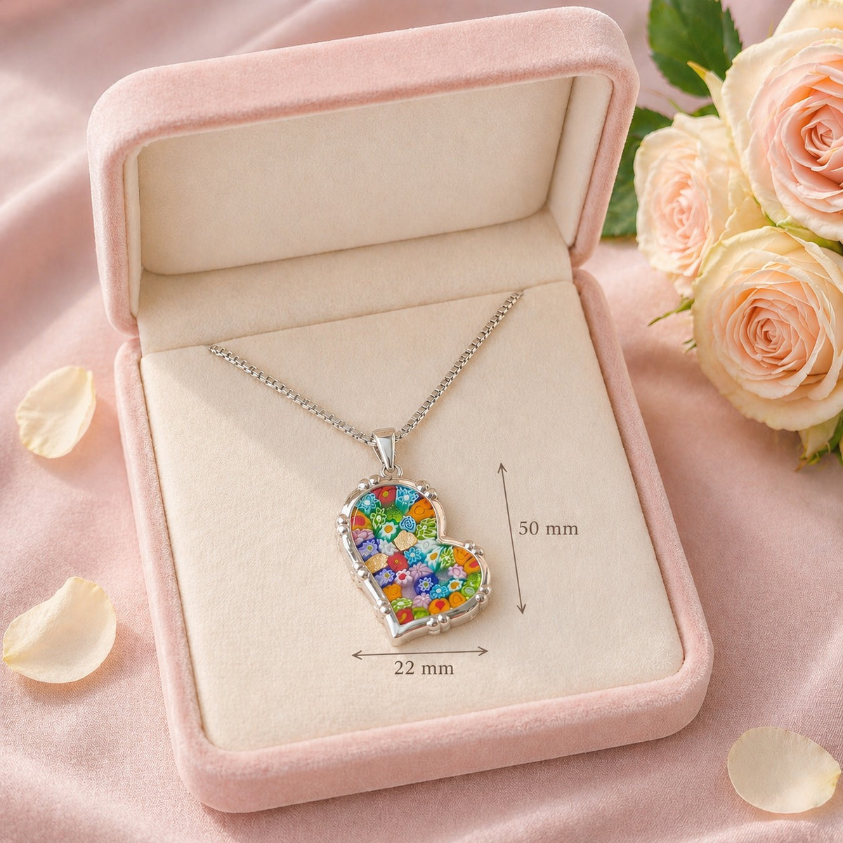 Heart-shaped colorful pendant necklace in a pink jewelry box with roses and petals.