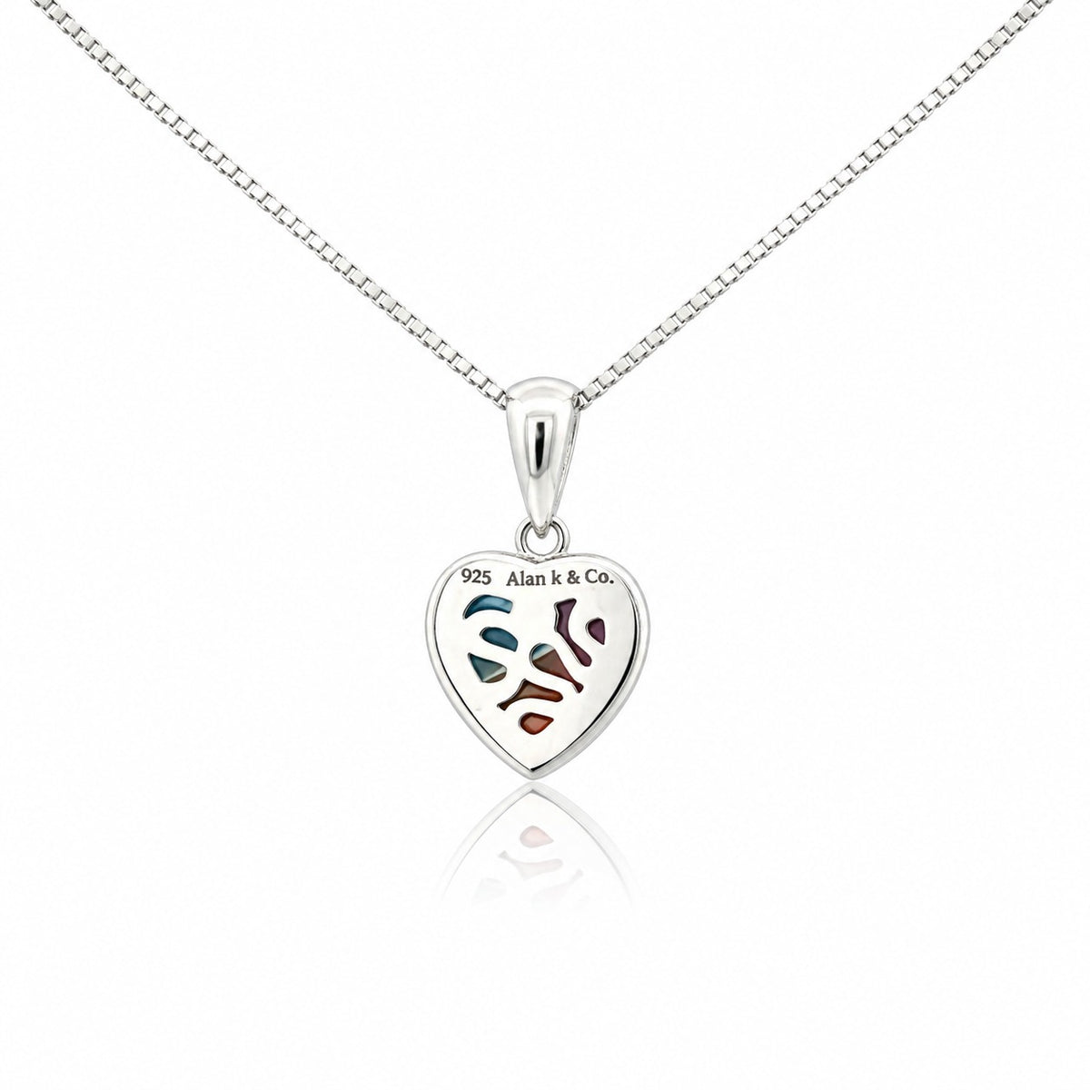 Silver heart-shaped pendant with engraved design on a white background