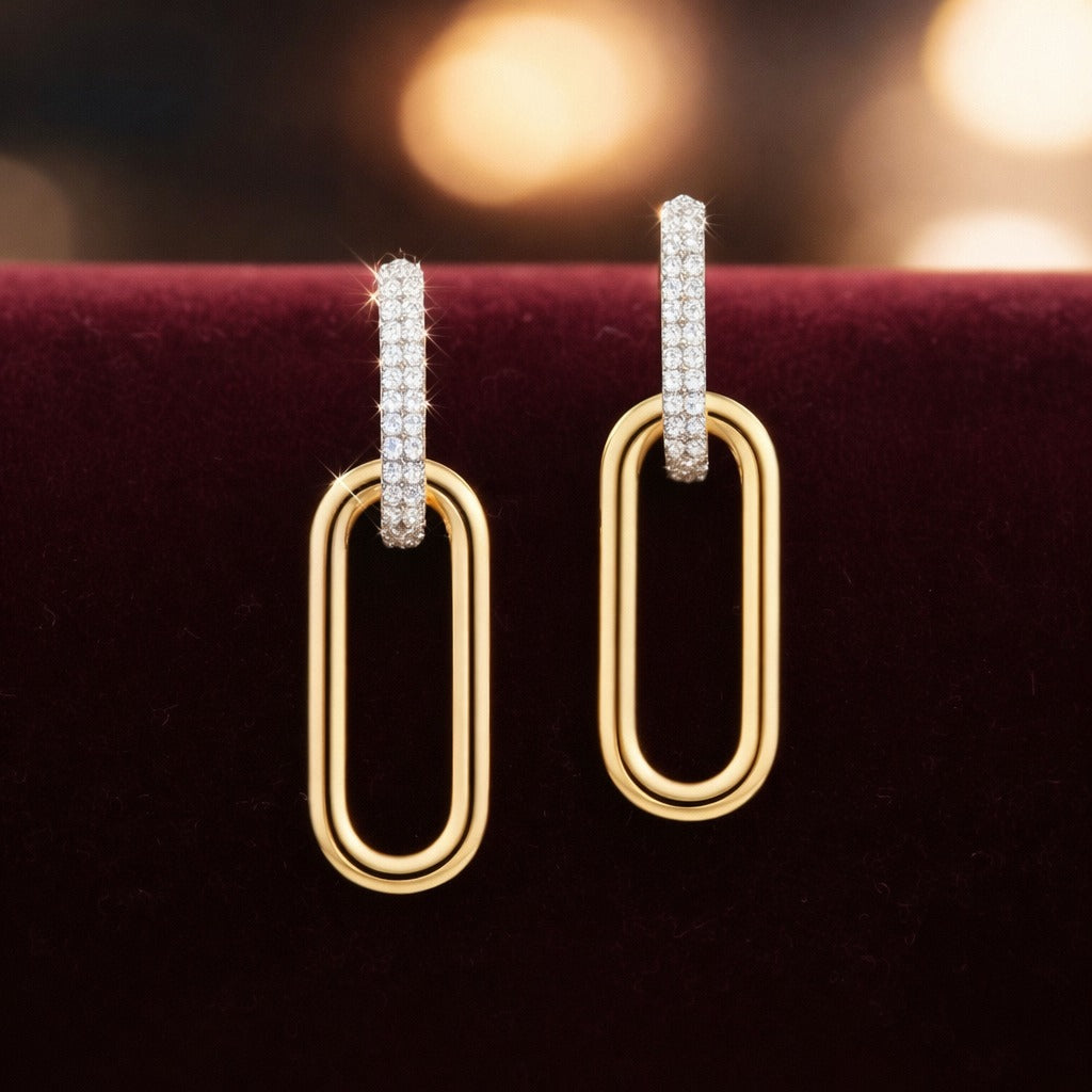Gold hoop earrings with diamond accents on a dark background