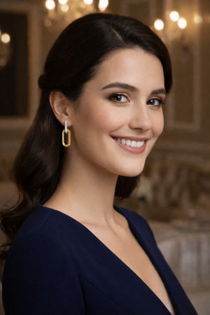 Woman wearing gold earrings in an elegant indoor setting