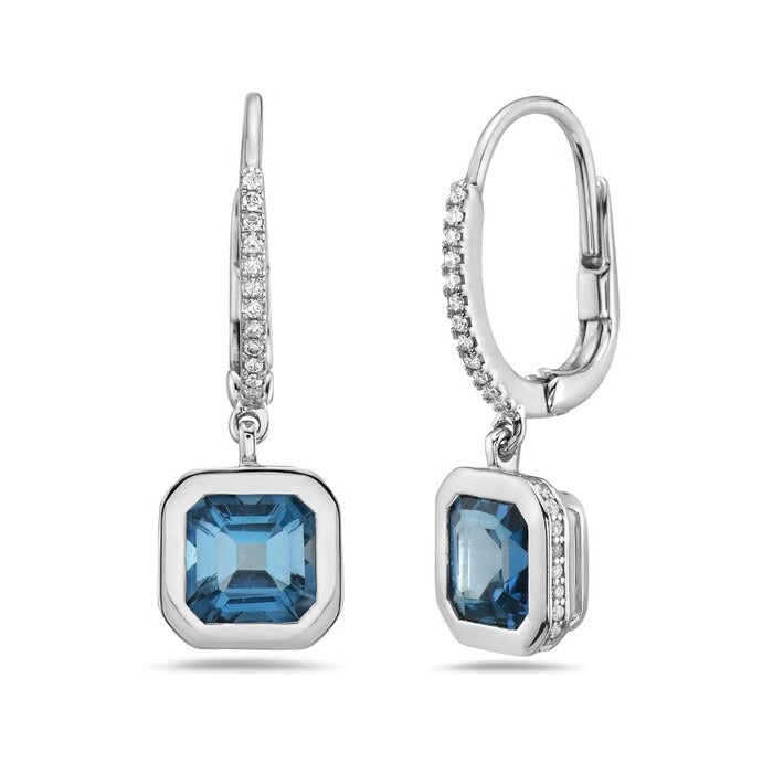 Pair of silver earrings with blue gemstones on a white background
