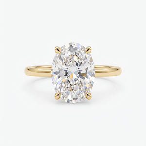 An oval-cut diamond engagement ring with a yellow gold band, shown on a clean, light gray background.