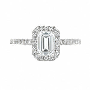 An emerald-cut halo ring featuring a central baguette diamond surrounded by a double halo of smaller round diamonds, with a pavé-set band in a silver-colored metal, shown on a plain white background.