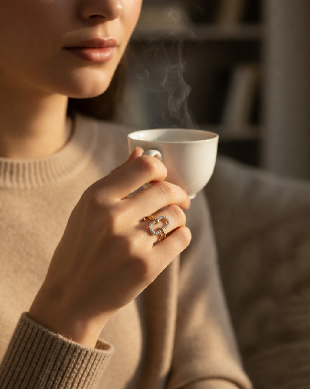 Person holding a steaming white mug with a blurred background