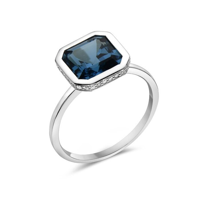 Silver ring with a blue gemstone on a white background