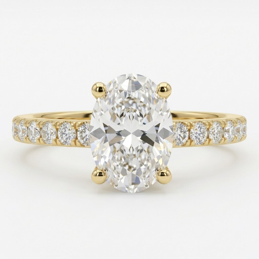 An oval diamond engagement ring with a yellow gold band featuring a row of small round diamonds on either side of the center stone, set against a clean white background.