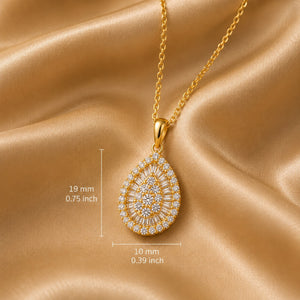Gold teardrop pendant necklace with a halo design, displayed on a gold chain over a champagne-colored satin background, with dimension markings showing 19 mm height and 10 mm width.