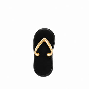 Black sandal with gold toe ring on a white background