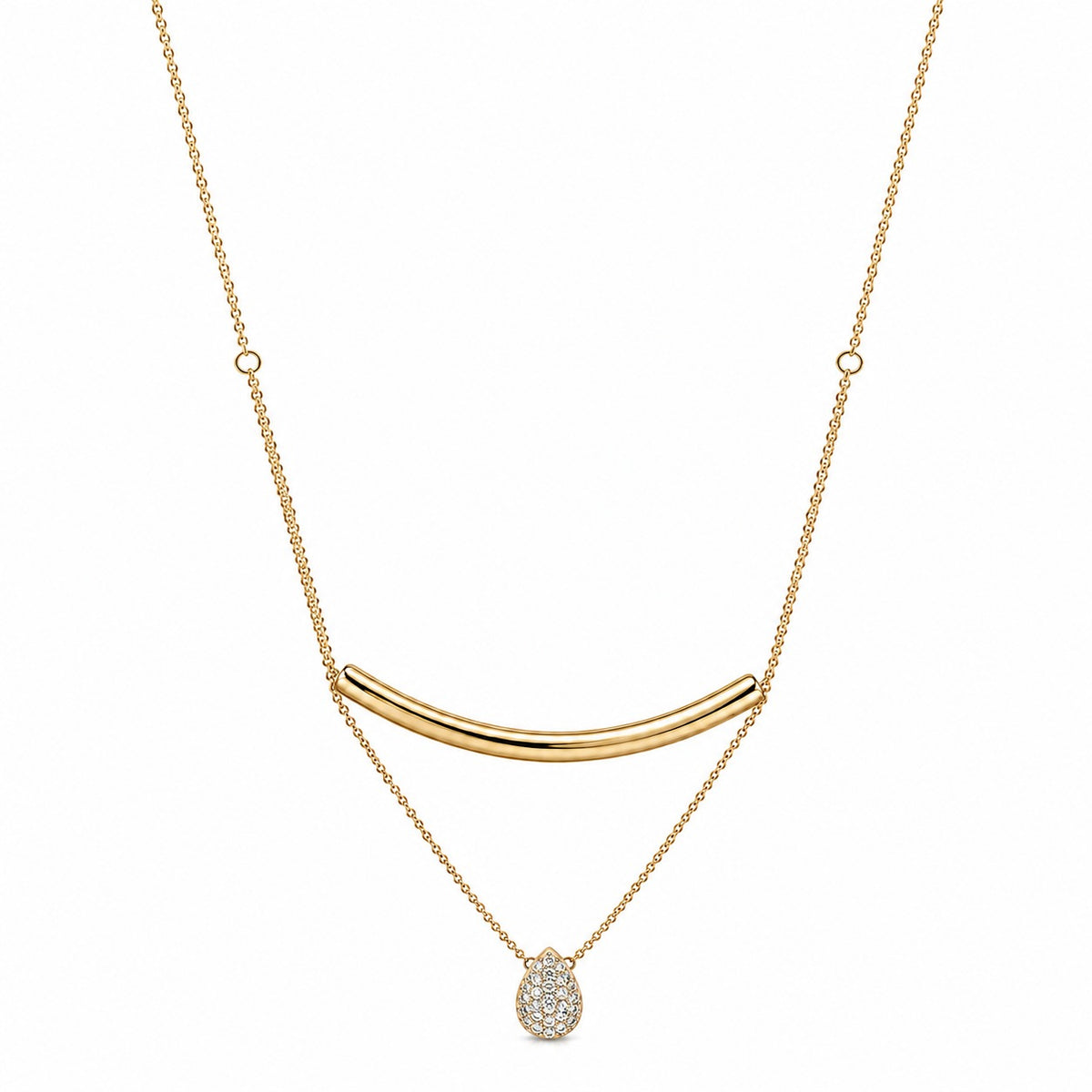 A gold necklace featuring a curved bar pendant, a delicate chain with small circular links, and a teardrop-shaped pendant paved with clear stones, shown against a plain white background.