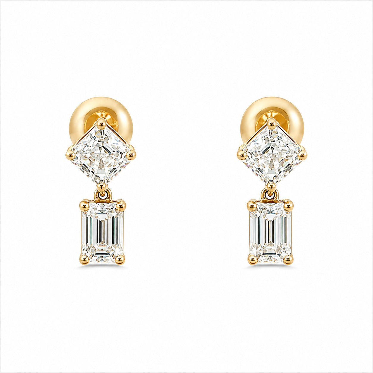 A pair of gold drop earrings featuring a brilliant round-cut clear gemstone above an emerald-cut clear gemstone, set in gold and photographed on a solid white background.