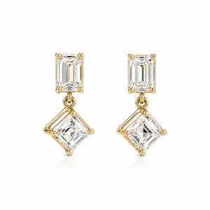 A pair of gold drop earrings featuring a rectangular baguette-cut clear gemstone in the top setting and a larger square princess-cut clear gemstone in the bottom setting, shown on a clean white background.