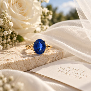 14K yellow gold ring featuring a 10 x 9mm oval deep blue sapphire in a four-prong setting.