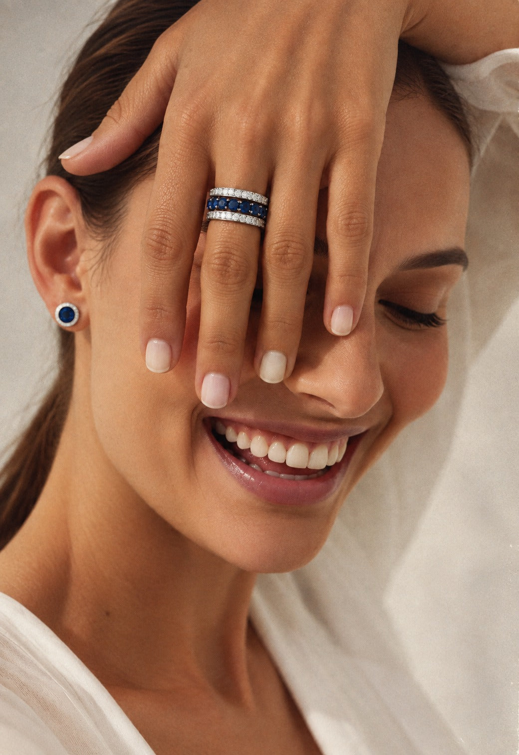 14K white gold open band ring featuring a vivid blue sapphire center row framed by two sparkling diamond rows.