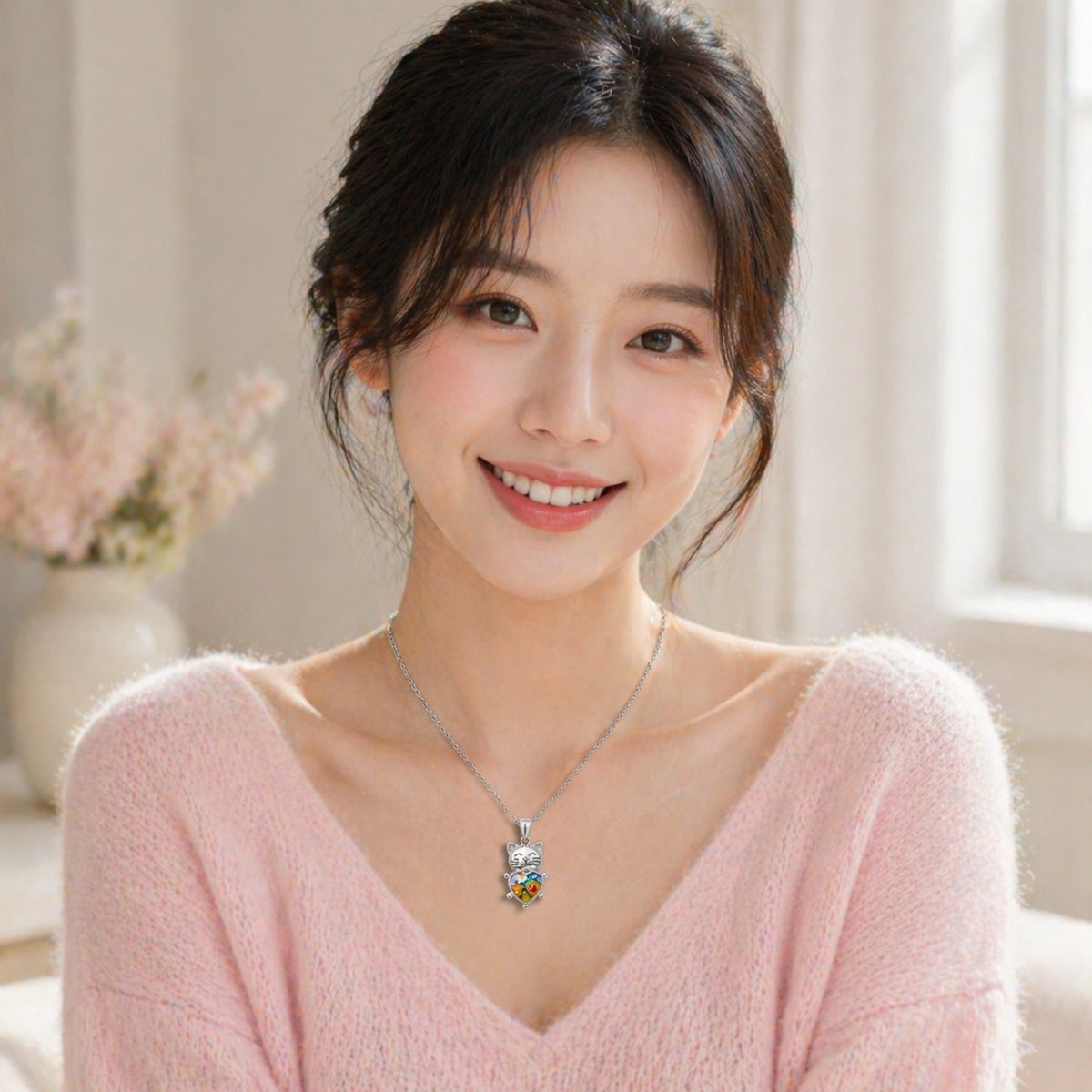 Woman wearing a pink sweater and a necklace with a colorful pendant indoors.