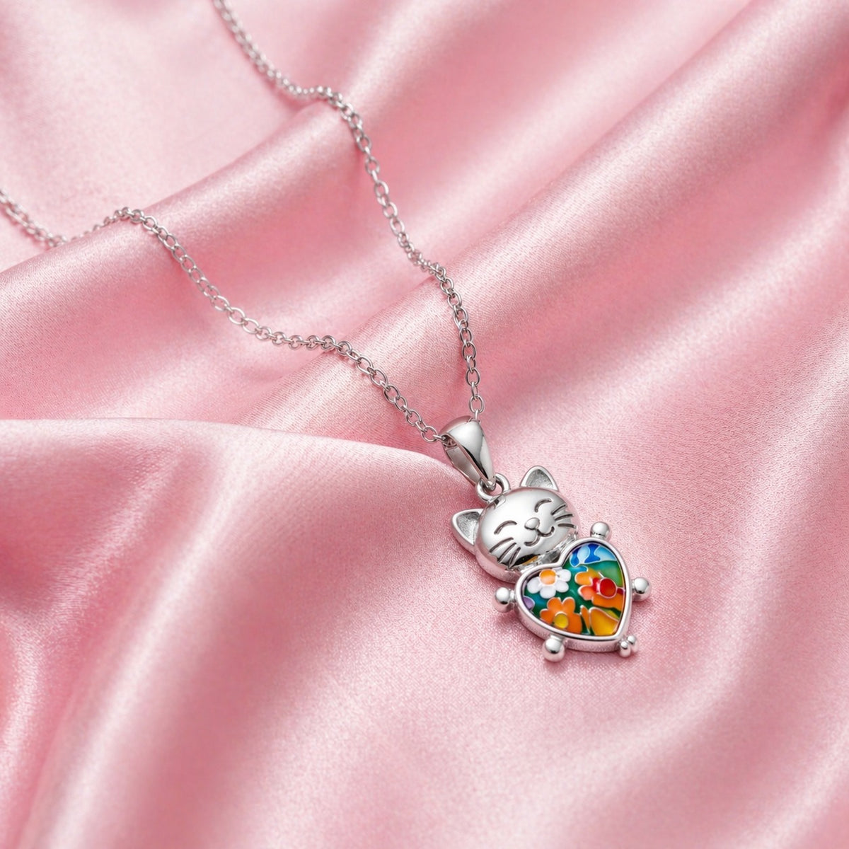 Cat-shaped pendant with colorful design on a pink satin background