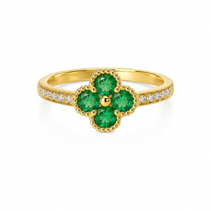 Gold floral ring with four green gemstones and diamond accents on the band.