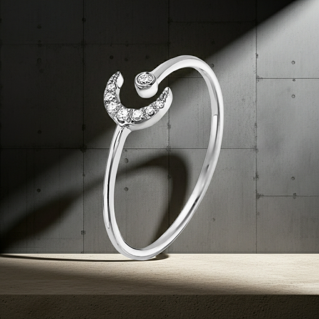 Silver ring with a crescent moon design on a dark concrete background