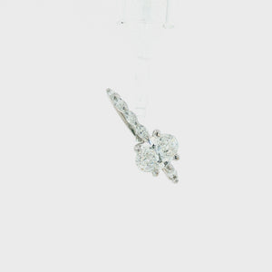 An oval diamond engagement ring with a brilliant center stone and marquise-cut side stones on a polished silver-colored band, set against a plain white background.