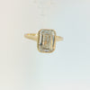 A yellow gold ring featuring a large rectangular emerald-cut clear gemstone in a bezel setting, shown against a plain white background.
