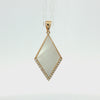 A gold pendant featuring a large, diamond-shaped white mother-of-pearl inlay bordered by small clear pavé stones, set against a plain white background.