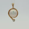 A gold pendant featuring a large, lustrous white pearl in a curved setting with a small round clear gemstone at the bottom, shown on a plain white background.
