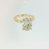 An oval diamond engagement ring with a yellow gold band, featuring a large oval-cut diamond set in a four-prong gold setting on a clean white background.