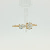 A yellow gold ring featuring a pear-cut diamond on the left and a round brilliant-cut diamond on the right, set on a polished gold band against a clean white background.