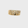 A wide yellow gold ring featuring a dense, graduated pattern of round-cut clear gemstones in a pavé-style setting, shown against a plain white background.
