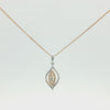 A two-tone leaf-shaped pendant necklace on a delicate gold chain, featuring a silver-toned outer border with pavé-set clear stones and a gold-toned center with yellow-stone accents, shown against a plain white background.
