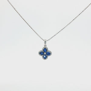 A 14K white gold bead chain necklace featuring a four-leaf clover pendant set with four vivid blue diamonds, accented by a sparkling halo of round white diamonds and a diamond cluster at the center, displayed on a clean white studio background.