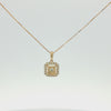 A gold square pendant necklace featuring a halo of small clear stones around a central round clear stone, suspended from a delicate gold chain on a white background.