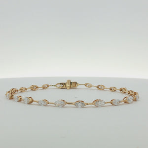 A yellow gold tennis bracelet featuring a series of marquise-cut and round diamonds set along the chain, displayed on a clean white background.